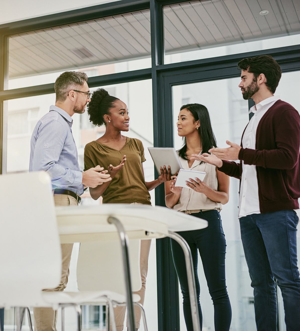 A group of professionals discussing ideas and collaborating in a modern office setting.